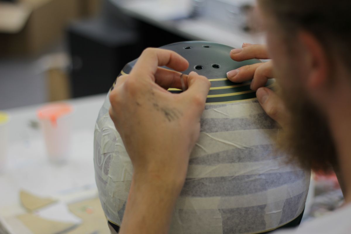 Ein Helm wird mit Streifen beklebt