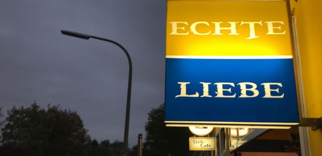 Beleuchtetes Kneipenschild mit der Aufschrift "Echte Liebe"