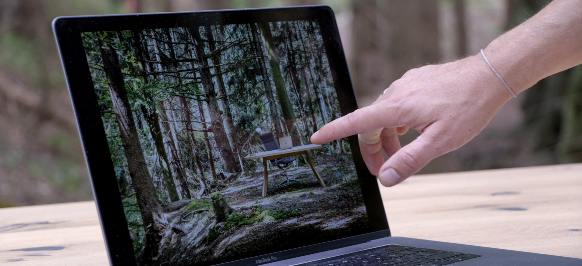 Hand zeigt auf etwas im Bildschirm eines Laptops