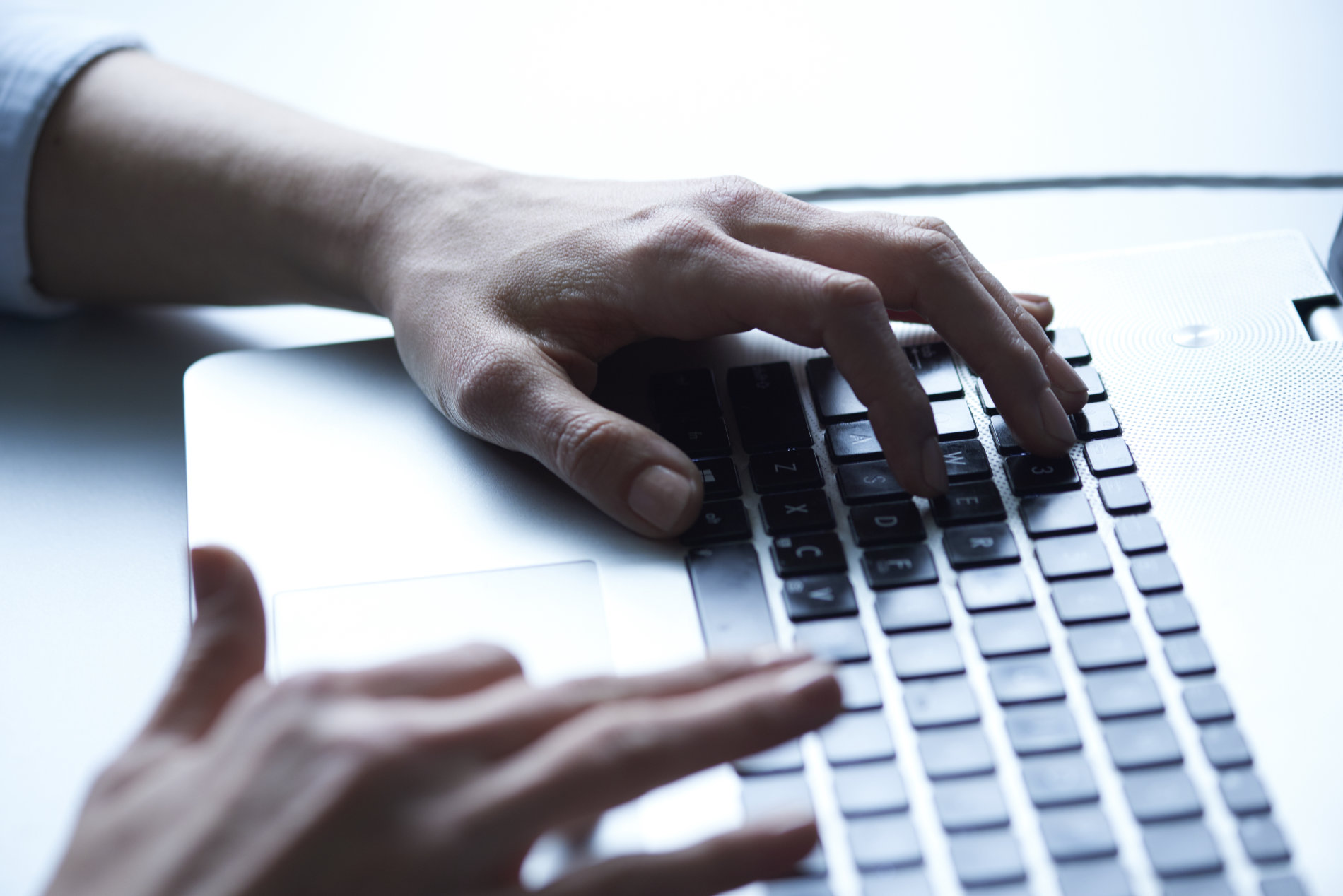 Hände auf einer Laptoptastatur