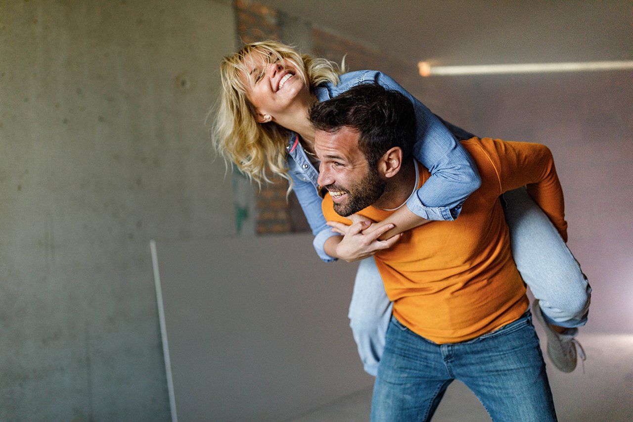 EIn junges Paar in einer Wohnung, sie ziehen gerade ein.