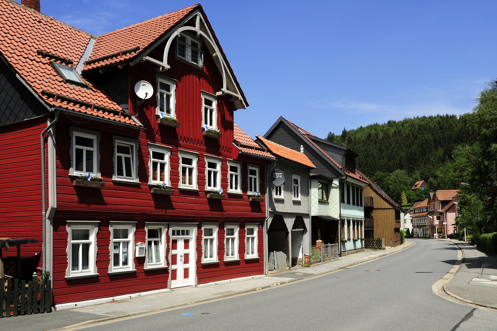 Man blickt auf ein rot verkleidetes Haus in der Ortschaft Wildemann im Harz.