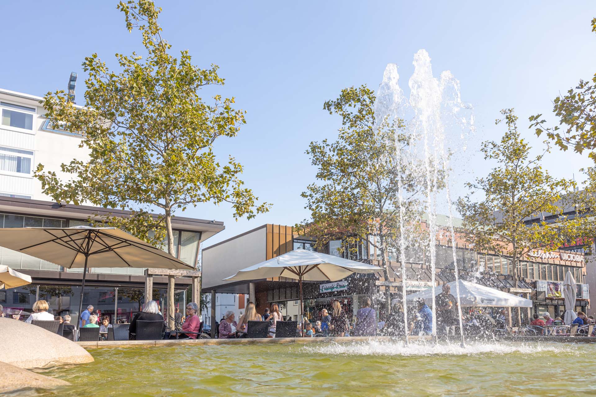 Man blickt auf einen Springbrunnen und Cafés in der Wolfsburger Fußgängerzone