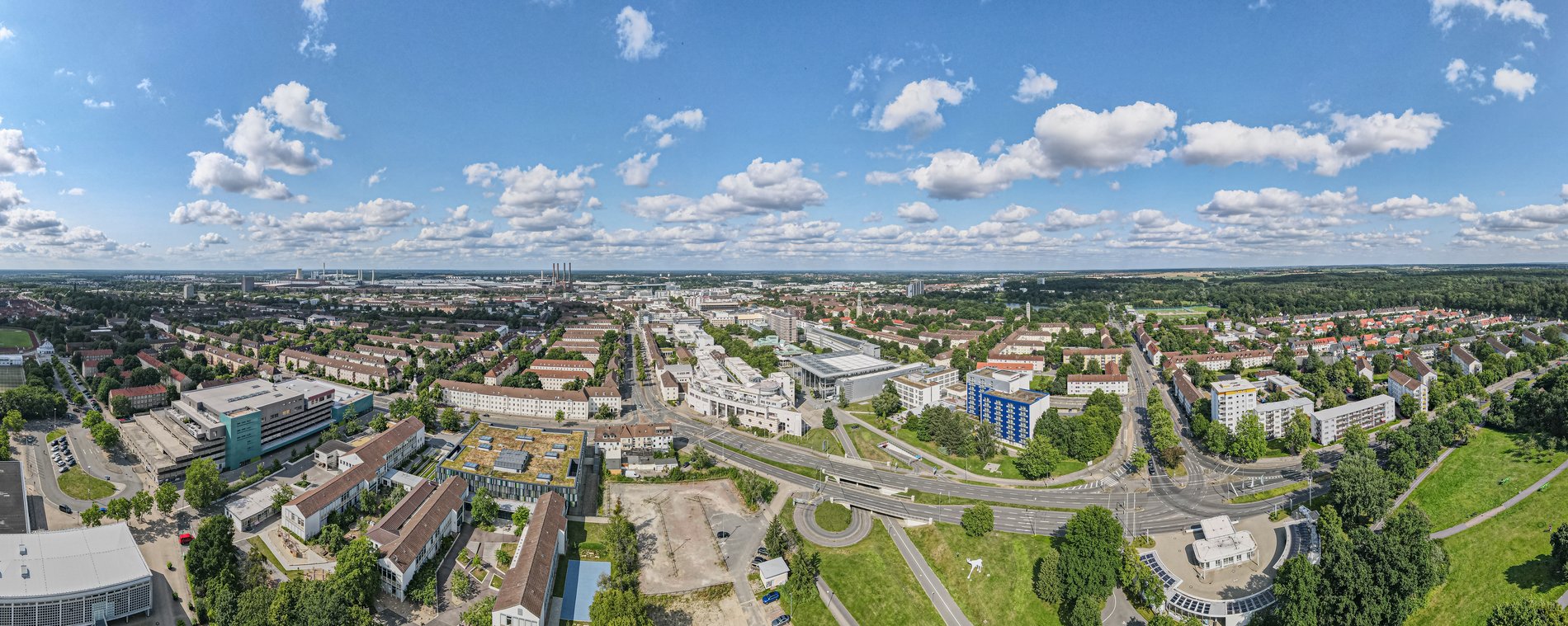 Man blickt aus der Luft über das Wolfsburger Stadtgebiet. Im Hintergrund ist vor allem Das Volkswagen-Werk zu erkennen. 