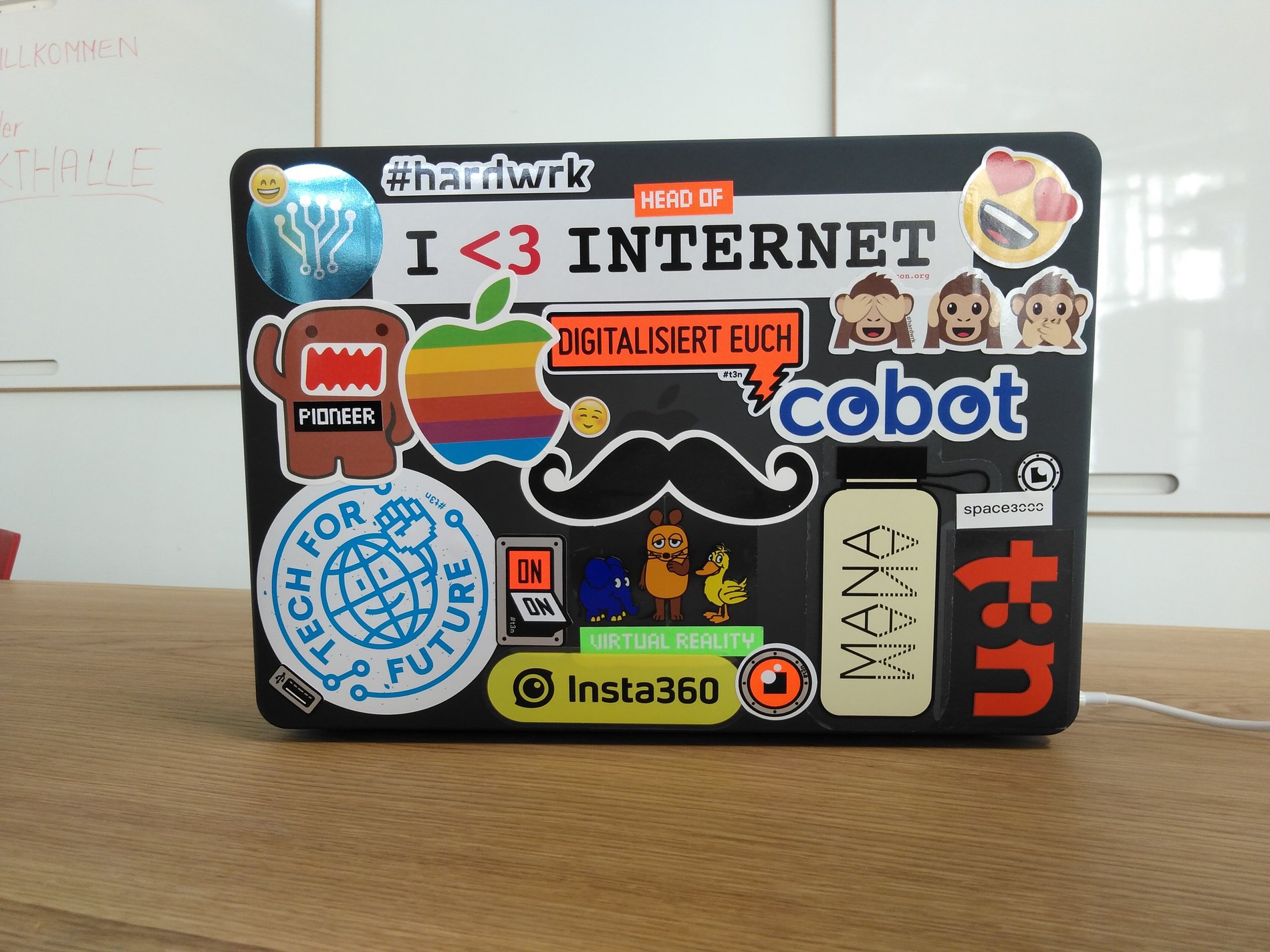 Die mit Aufklebern bedeckte Rückseite eines Laptops.