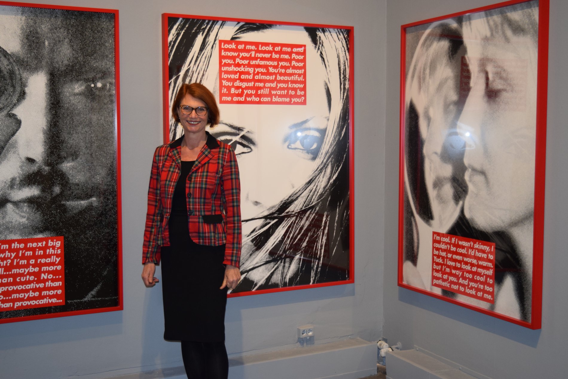 Vor den Werken von Barbara Kruger steht Direktorin Dr. Bettina Ruhrberg.