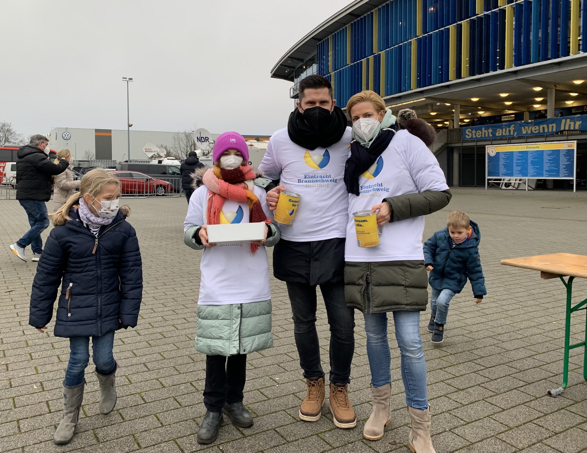 Eine Familie steht vor einem Stadion.