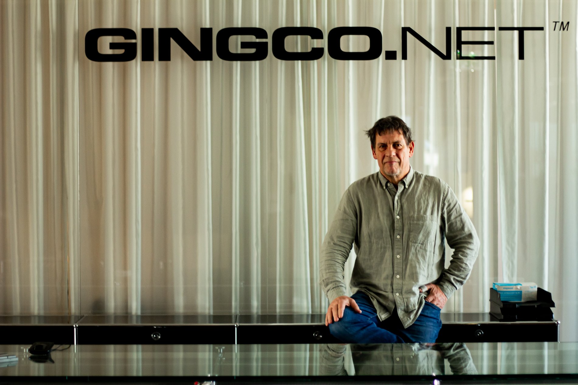 Ein Mann steht vor dem Firmenlogo von Gingco.net.