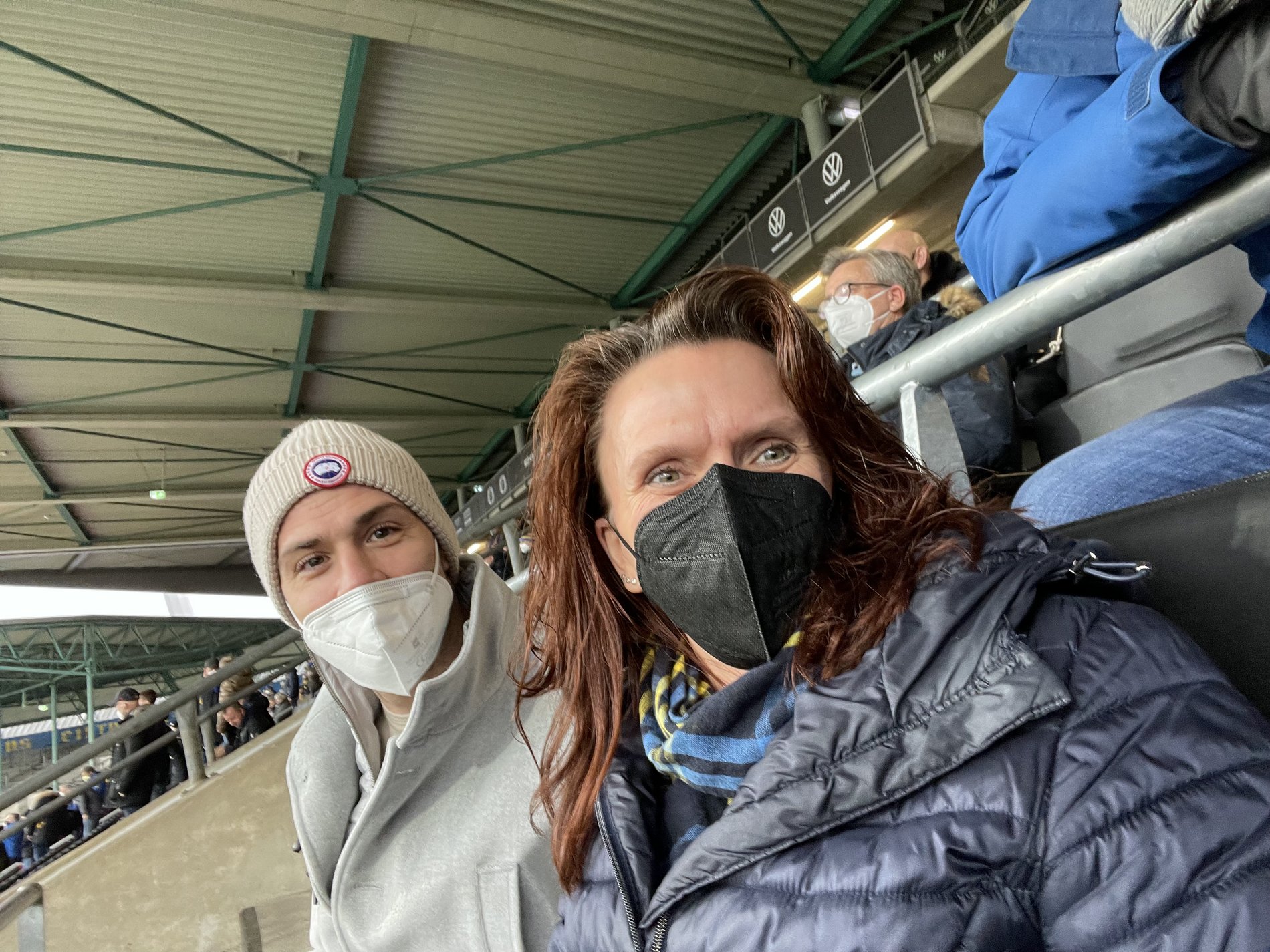 Ein Mann und eine Frau sitzen in einem Fußballstadion.