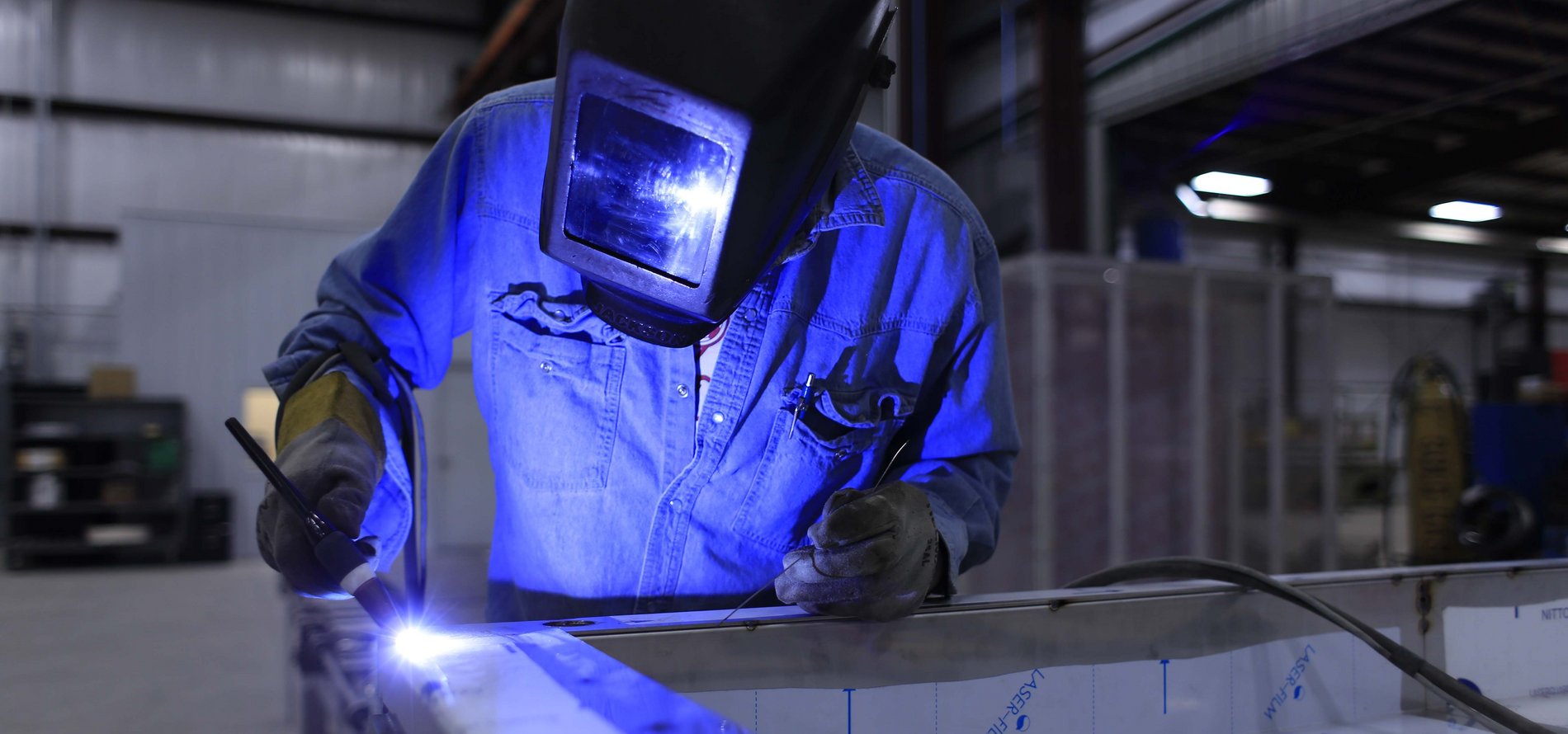 Ein Mann schweißt an einem Metallträger.