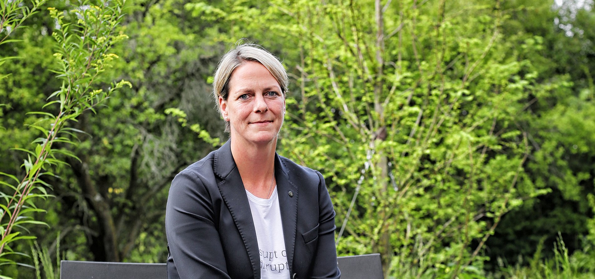 Eine Frau sitzt in einem Garten.