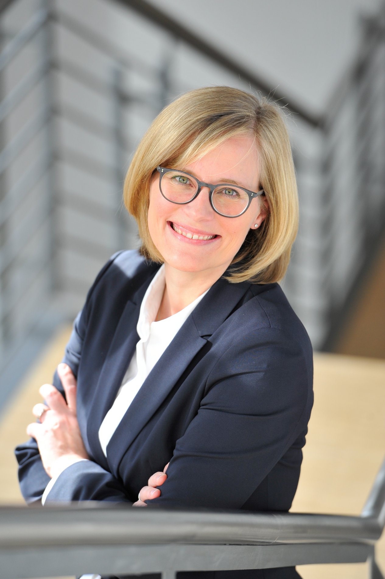 Eine blonde Frau mit Brille.