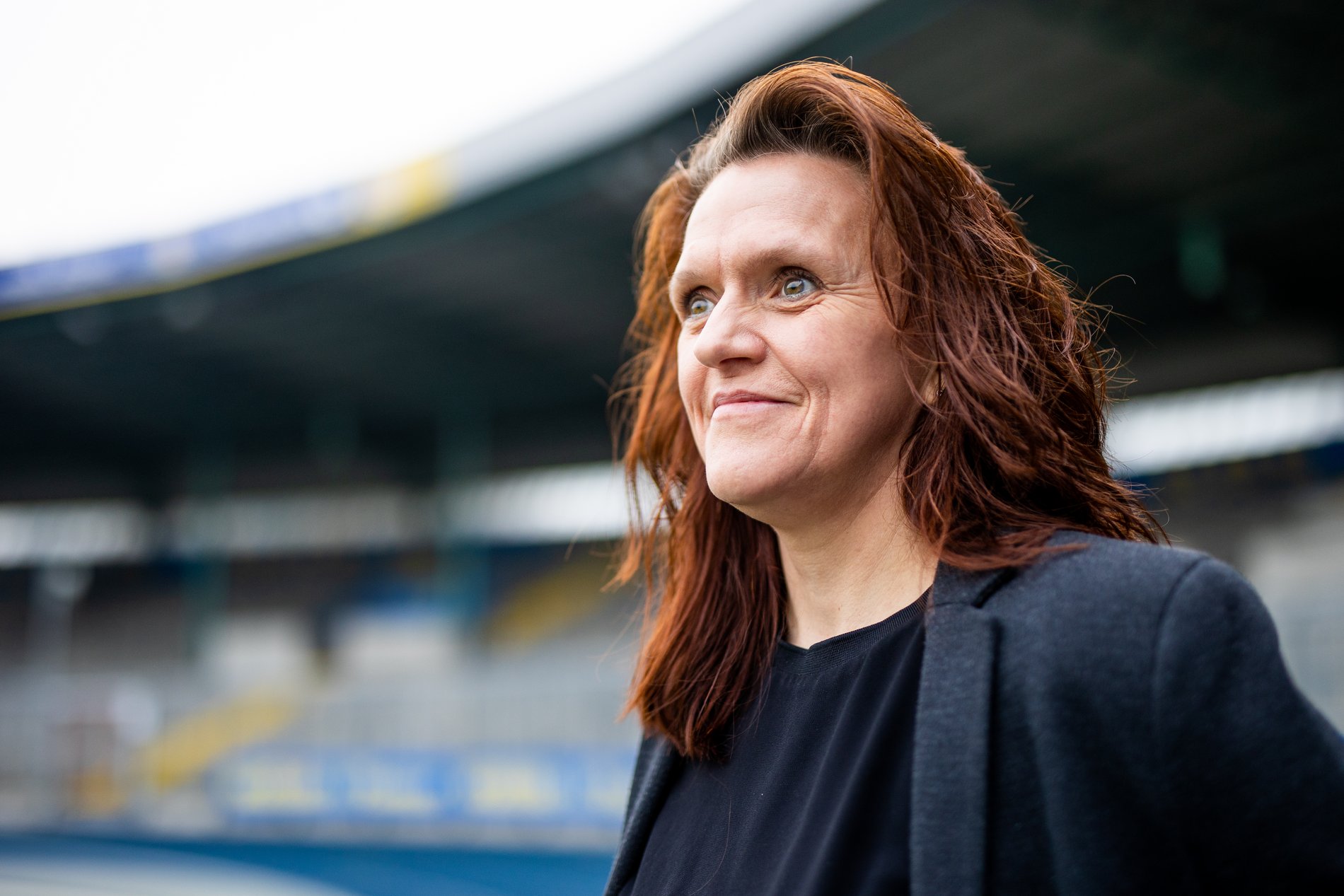 Eine Frau steht in einem Fußballstadion.