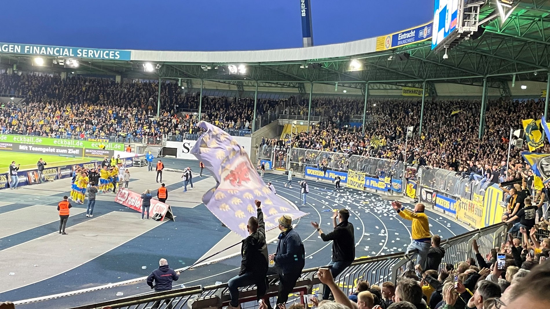 Eine Fußballmannschaft lässt sich nach einem Sieg von ihren Fans feiern.