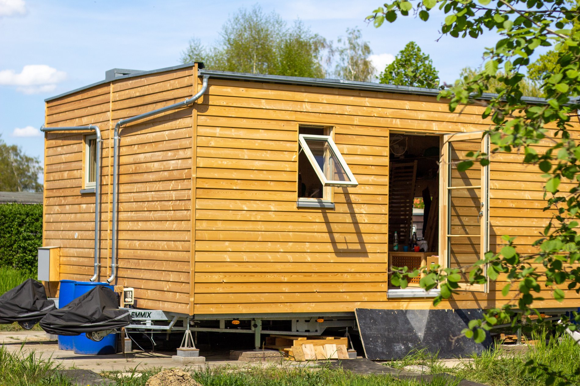 Ein Tiny House. Seine Wände sind aus Holz.