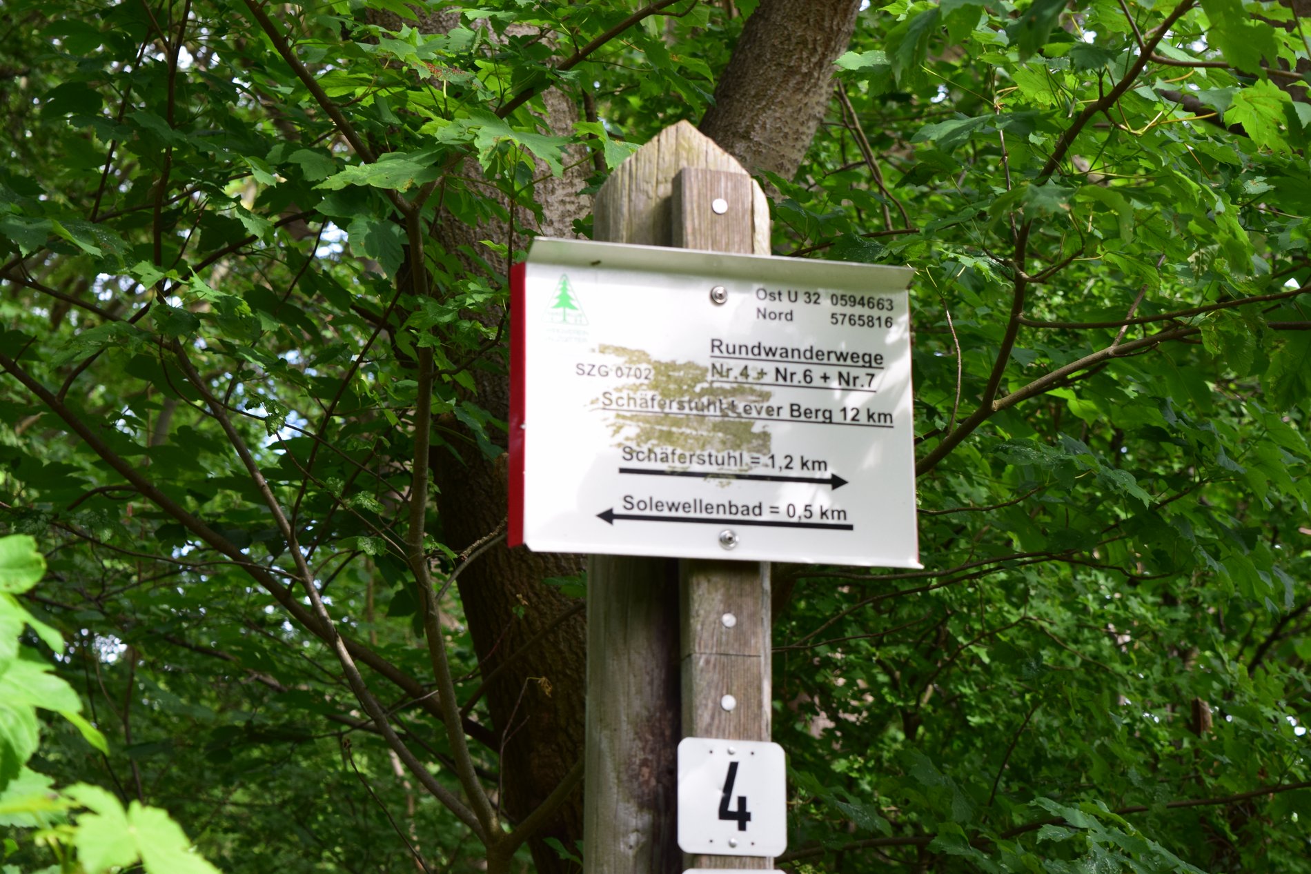 Ein Schild mit entfernungsangaben für Wanderer.