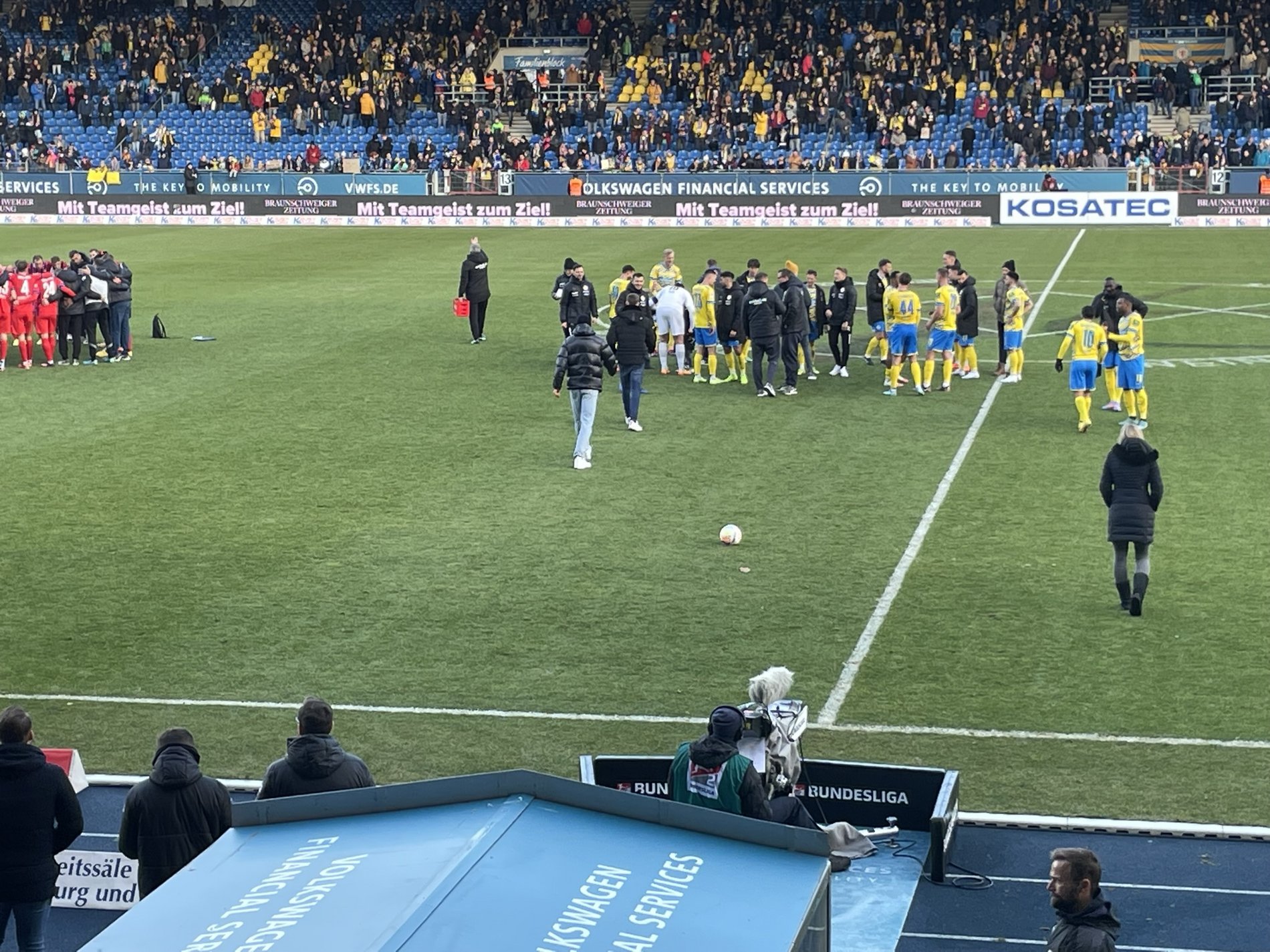 Spielende im Eintracht-Stadion, Team und Betreuer begegnen sich im Mittelkreis. 