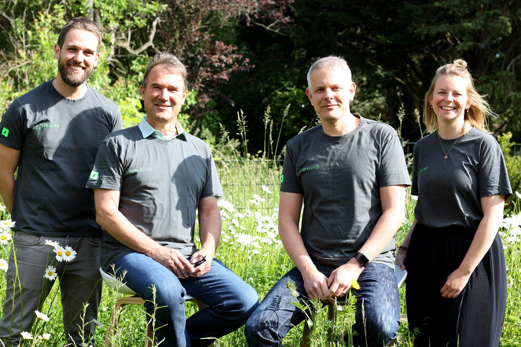 4 junge Leute in einheitlichen T-Shirts.