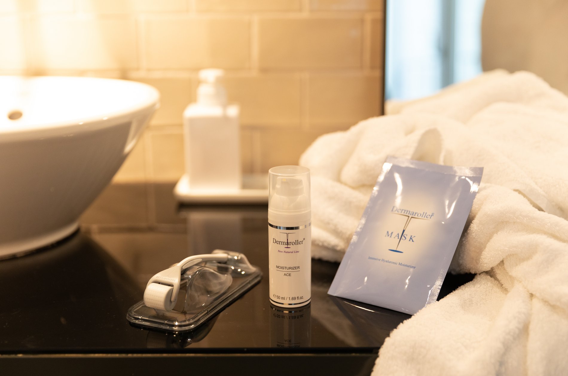 Klassischer Dermaroller und dazugehörige Kosmetikprodukte. 