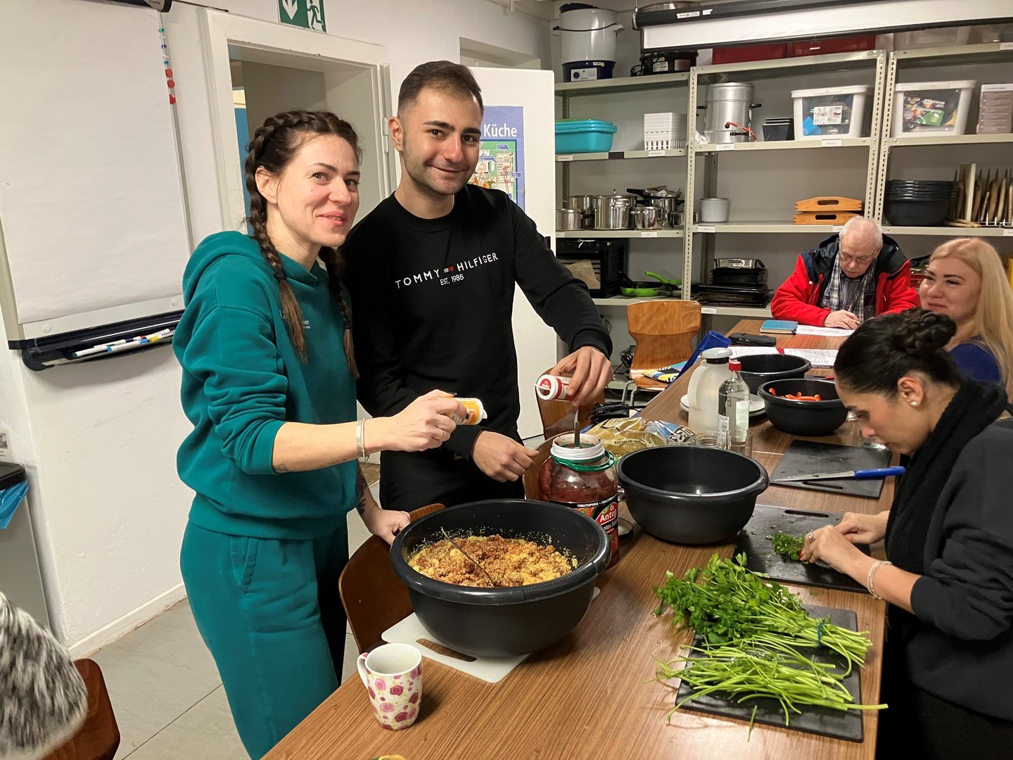 Gemeinsam kochen im Stadtgarten Bebelhof. Links Daria Levchenko und Yasar Atikler. Rechts ist Oksana Chemolosova zu erkennen. 