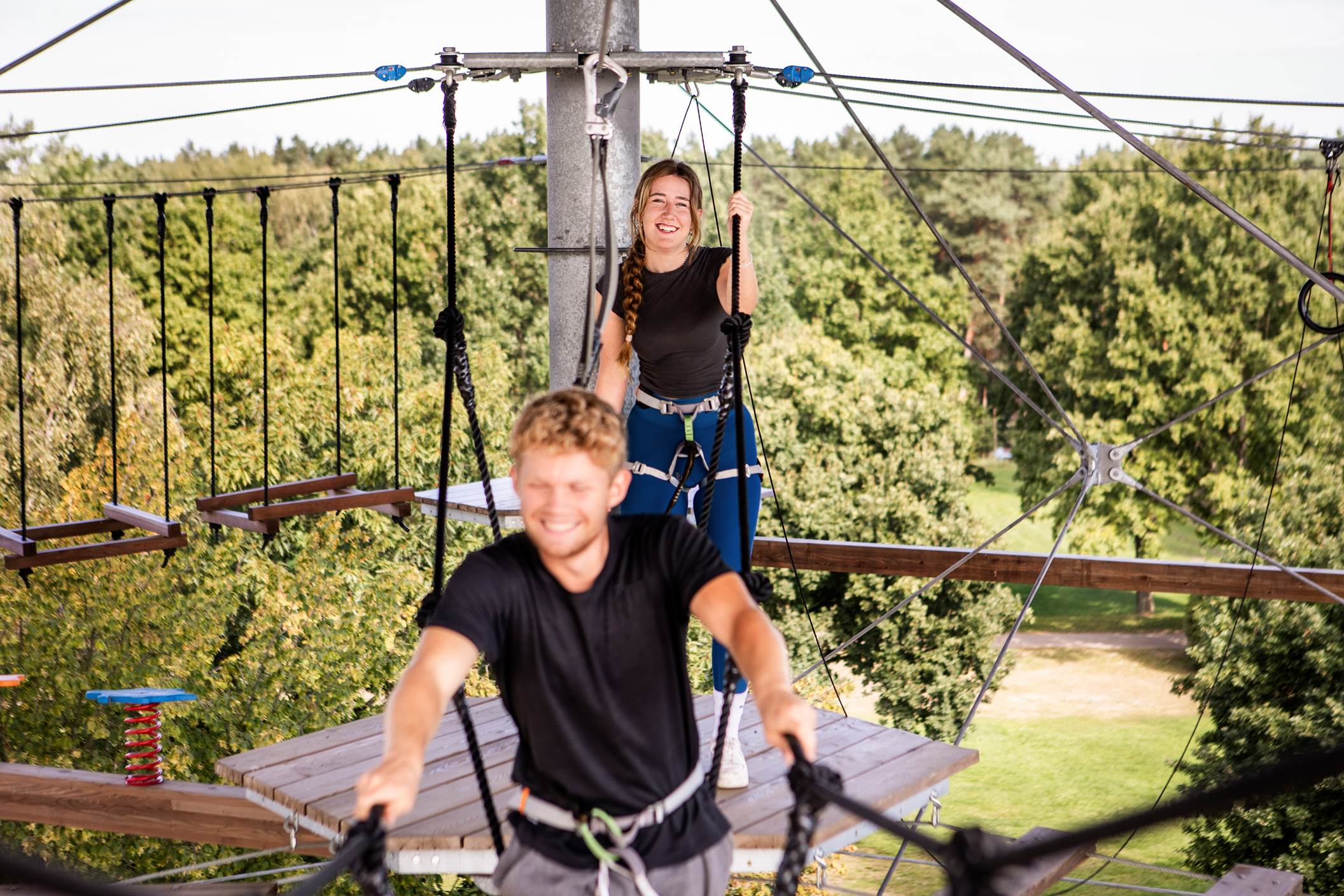 Ein junges Paar klettert auf dem Erlebnisturm am Tankumsee.